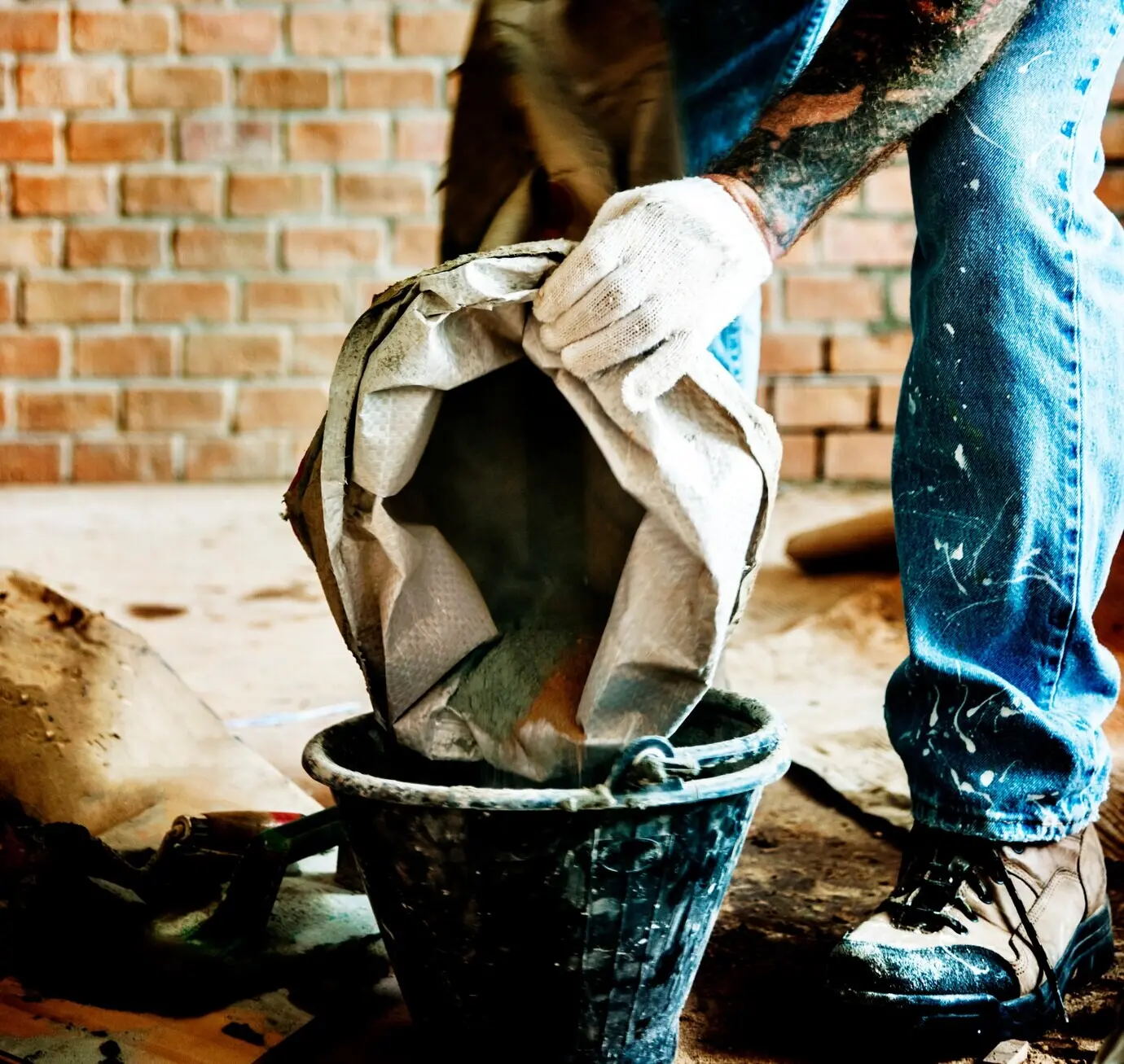 A handyman prepares cement for use in construction.